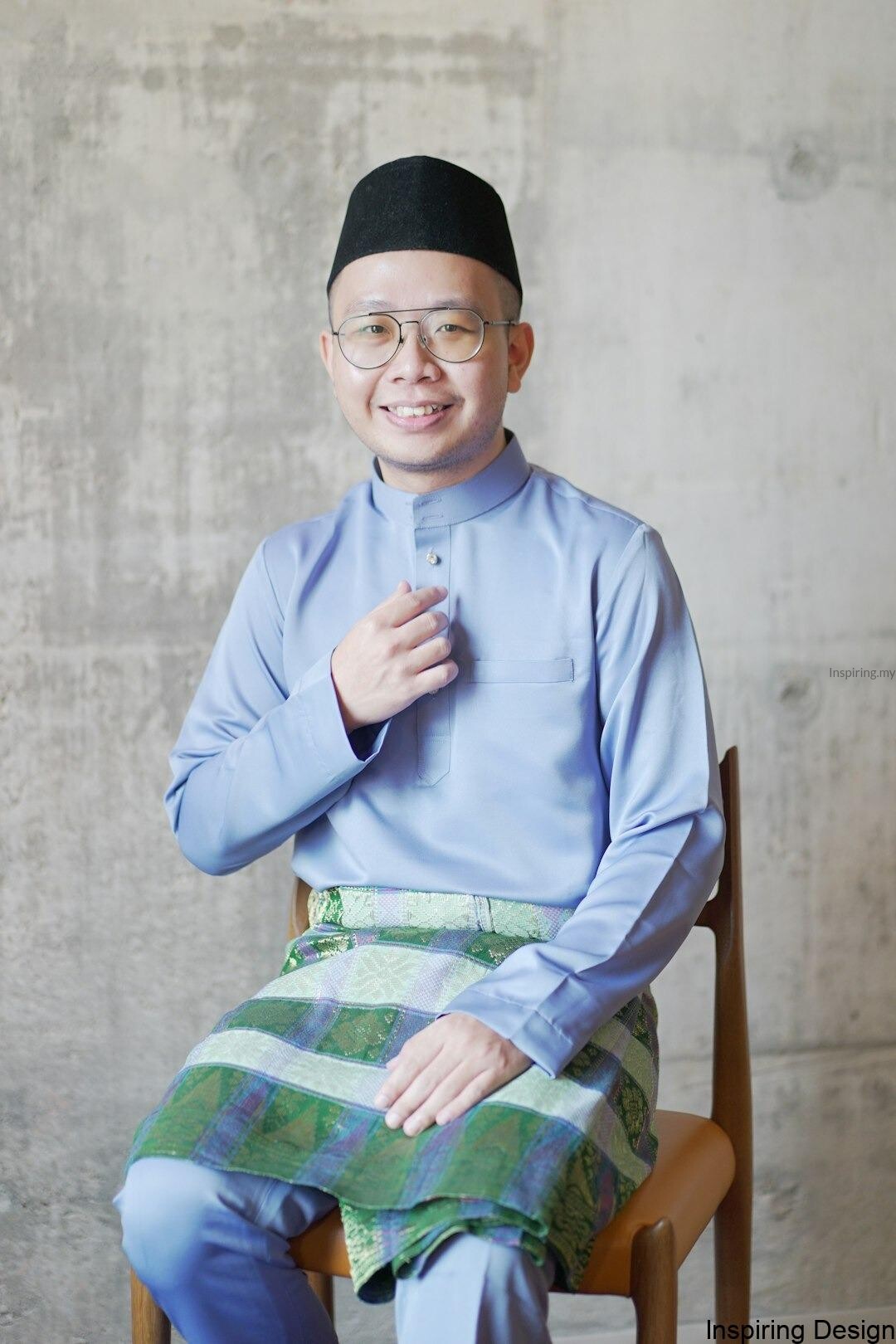 man in blue dress shirt and green and white plaid skirt